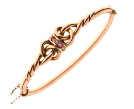 Yellow metal (9ct 'rose gold'), ruby and tinted split pearl snap bangle, of knotwork design, 8.4g gross approx