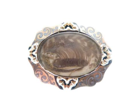 Victorian gilt and enamel mourning brooch with seed pearl-enriched hair ornament beneath oval glazing.