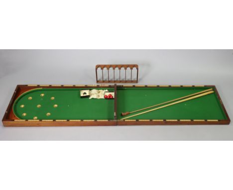 A late 19th/early 20th century mahogany folding table-top bagatelle board (split to top, inset green baize, 53cm x 213cm (ope