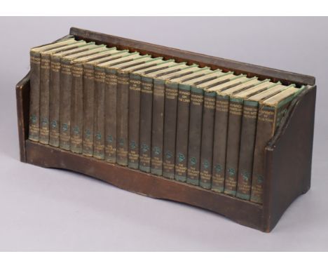 A set of twenty 1930s volumes “The New Punch Library”; together with an oak book-trough, 23¼” wide.