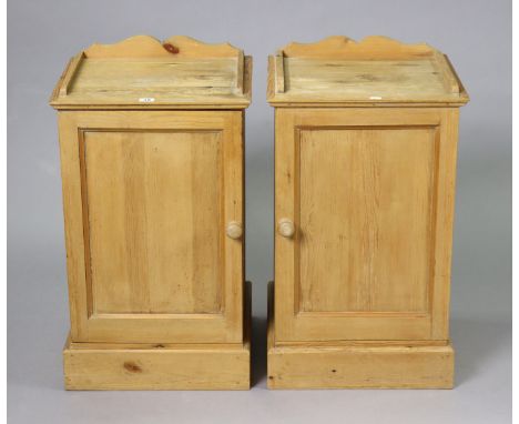 A pair of pine tray-top bedside cupboards each fitted centre shelf enclosed by a panel door, &amp; on a plinth base, 42cm wid