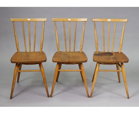 A set of three Ercol spindle-back kitchen chairs each with a hard seat, &amp; on round tapered legs with spindle stretchers.