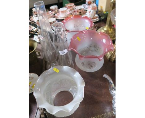 A pair of frosted etched and cranberry oil lamp glass shades, together with another frosted glass shade and six glass oil lam