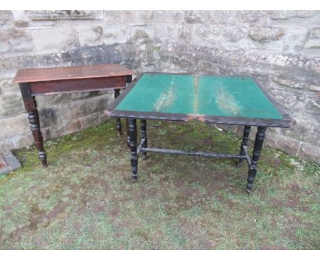 An ebonised fold over card table, of rectangular form, raised on four turned legs united by stretchers, 39.5ins x 19ins x hei