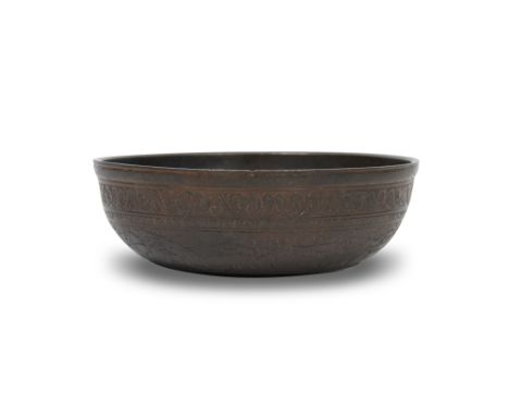 AN ENGRAVED BRONZE QAJAR DRINKING CUPQajar Iran, late 19th century
Of typical shallow rounded shape, the interior plain excep