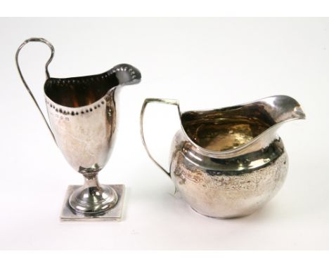 A George III silver helmet shape milk jug, Solomon Hougham, London 1810, with a foliate engraved frieze, and a Victorian silv