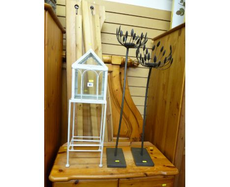 Pair of black metal ornate floorstanding candleholders and a white painted metal and glass small furnishing item