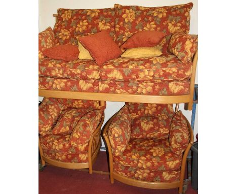 A contemporary Ercol blond elm 3-piece suite, comprising; three-seater sofa and pair of armchairs, with red floral cushioned 