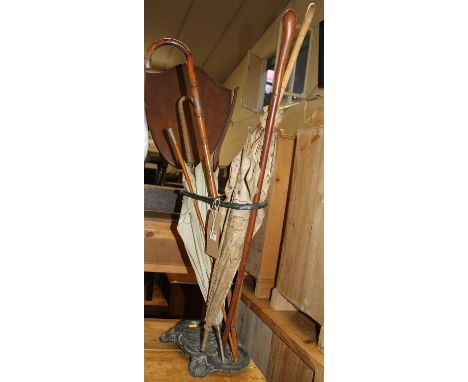A Victorian cast iron twin division stick stand with sundry contents