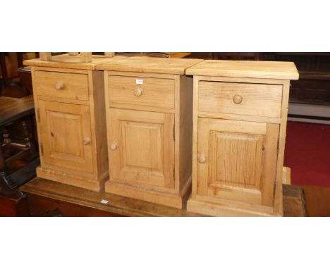 A set of three contemporary pine single door bedside cupboards, with single upper drawers, w.42.5cm; together with a small li