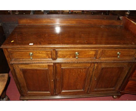 A 1930s oak ledgeback three door sideboard, having three frieze drawers, w.135.5cmColour is very good. Some light marks. Very