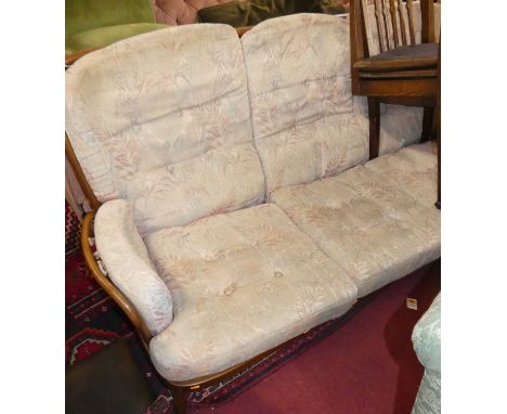 An Ercol mid-elm stickback three-seater sofa, with fabric upholstered squab cushions, on turned supports, w.185cm