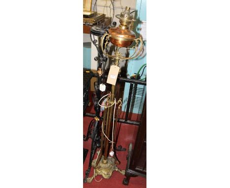 An early 20th century brass and copper standard lamp (converted from a paraffin lamp); and one other black painted wrought ir
