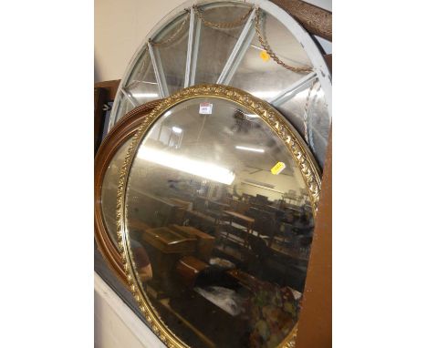 A gilt composition framed and bevelled oval wall mirror, dia.64cm; together with a gilded and bevelled oval wall mirror; and 