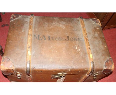An early 20th century canvas, wood, leather and metal bound hinged travelling trunk, titled MA Ivor Jones, width 70cm
