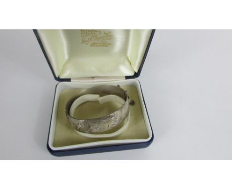 A silver hinged bangle, Birmingham 1977, with an engraved frontispiece, 45g gross, cased