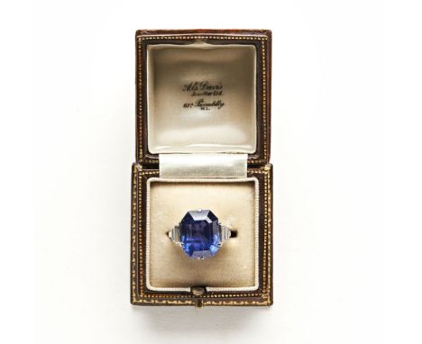 A sapphire and diamond ring, the step cut stone measuring approximately 13.9 mm by 10.3 mm by 8.8 mm deep, with three graduat