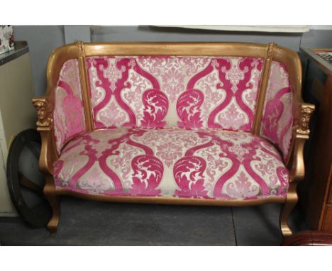 A 20th century two seater sofa, upholstered in a pink fabric, in a painted gilt frame,  95cm high, 125cm long, 52cm deep