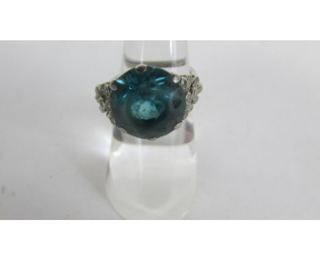 A blue zircon and diamond ring, stamped 'Plat', the round cut stone approximately 12mm by 7 mm deep, with four single cut and