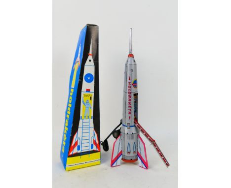 A tin plate 'Holdraketa' moon rocket model. Model is 39 cm in height. Model's wheels performs a folding movement as well as s