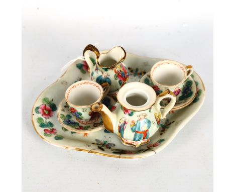 A Chinese famille rose porcelain doll's tea service on matching tray, tray length 14cmTray has a staple repair on the rim. Ju