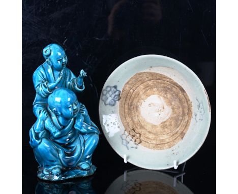 A Chinese blue glazed ceramic figure of 2 children playing, height 20cm, and a 15th/16th century glazed porcelain dish, diame