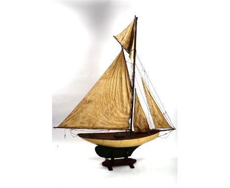 A large Vintage wood-hulled model pond yacht, with sails and rigging, on stand, total length approx 150cm, height 185cmGenera