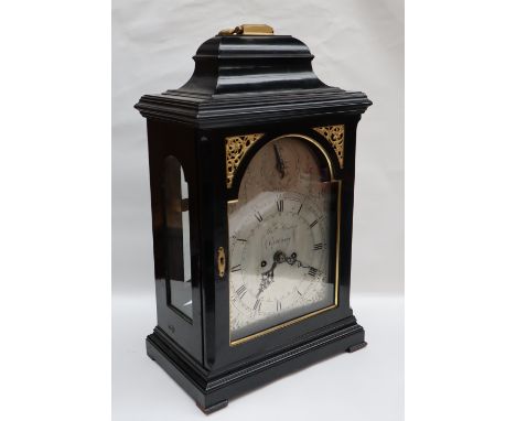 An 18th century ebonised bracket clock, with a brass carrying handle and caddy top glazed doors and sides with gilt spandrel,