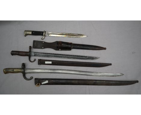 A French 1864 sabre bayonet and scabbard together with a Japanese Arisaka 1897 pattern bayonet and scabbard and a German Worl