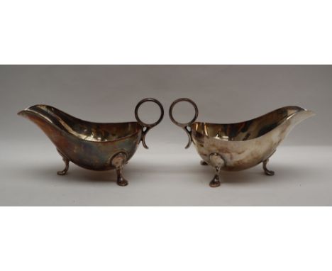 A pair of George VI silver sauce boats of usual form with ring handle and three legs with pointed pad feet, Sheffield, 1943, 