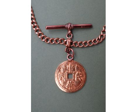 A yellow metal long chain, with twisted oval links and a T bar marked 9ct, 52cm long, with a yellow metal Chinese coin attach