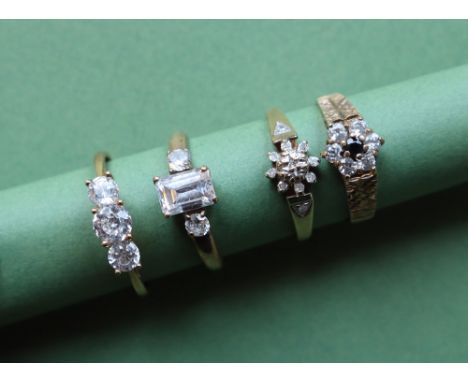 A 9ct gold three stone ring set with Cubic Zirconiums, together with three other 9ct gold rings, overall approximately 8 gram