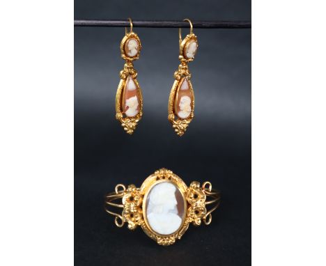 A 19th century continental yellow metal shell cameo bangle together with a pair of yellow metal mounted shell cameo drop earr