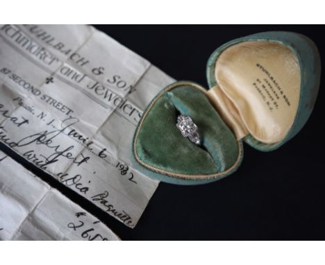 A diamond ring set with a central old round cut diamond approximately 0.8cts with baguette cut diamond shoulder to a white me