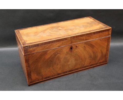 A 19th century mahogany tea caddy of rectangular form, the crossbanded hinged top enclosing two lidded compartments and a cen