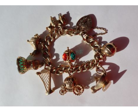 A 9ct yellow gold bracelet, with oval twisted links set with numerous  9ct gold charms, including a jug, lantern, carriage, h