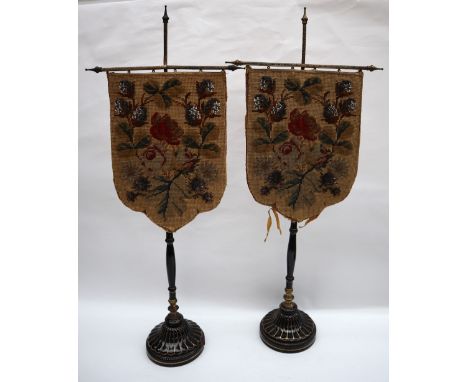 A pair of 19th century tapestry table top face screens with shield shaped woolwork panels decorated with flowers and leaves o