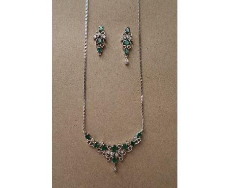 An Emerald and diamond necklace set with eight oval faceted emeralds and old round cut diamonds to an 18ct white gold setting