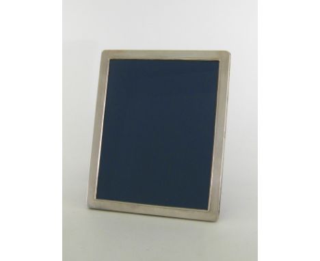 A modern silver photograph frame by Richard Comyns, Sheffield, 1992, plain oblong with rounded corners, blue velvet easel bac