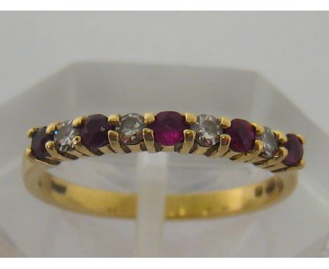 An 18 carat yellow gold, diamond and ruby nine stone ring, finger size K, 2 gms 
