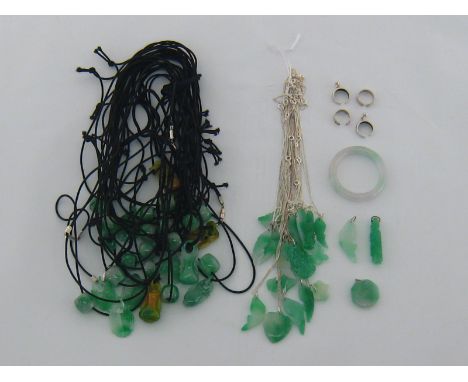 A quantity of modern carved jade pendants, eighteen on fine silver chains, twenty-seven on black elasticated cords, and four 