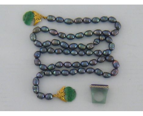 A cultured black pearl and jade necklace, composed of 66 cultured pearls, to gold mounted (tests as 14 carat) carved and pier