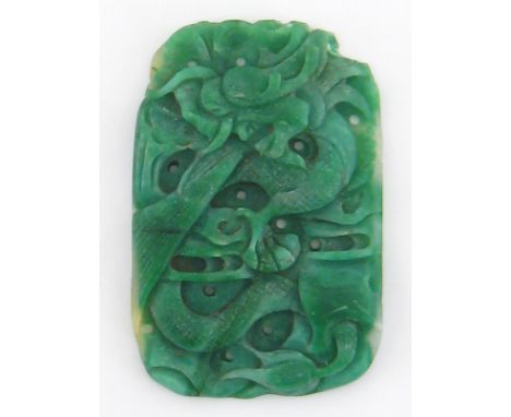 A carved jade amulet, the oblong body carved in relief with fish hiding amongst reeds, crudely incised with a further scrolli