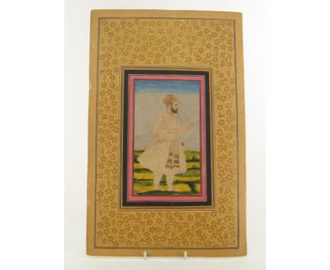An Indian miniature painting of a figure holding a ruled block and stylus, possibly a surveyor, in a landscape. Image 10x18cm