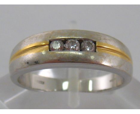 An 18 carat white gold and diamond ring, of contemporary design, the three small brilliants tension set in a central aperture