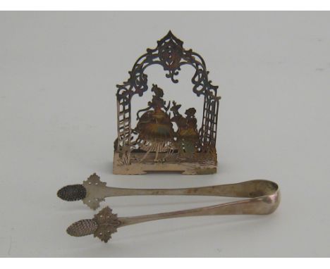 A German silver napkin holder, circa 1910, arched openwork form with 18th century courting couple to either side, also a pair