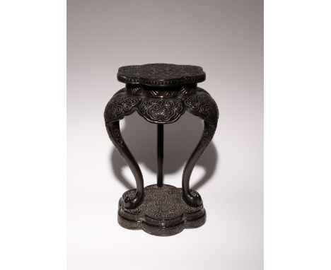 A TIHEI LACQUER TRIPOD STAND 18TH/19TH CENTURY The lobed top carved with concentric bands of pommel scrolls encircling a cent