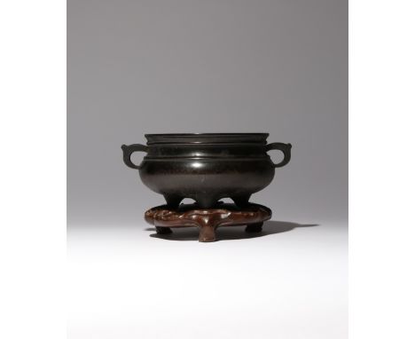 A CHINESE BRONZE TRIPOD INCENSE BURNER QING DYNASTY OR LATER The compressed body raised on three tapering feet, set with two 