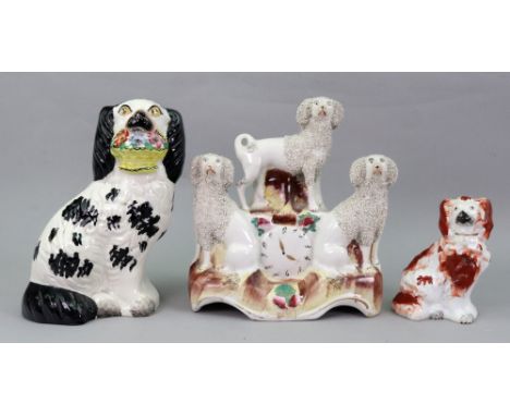 A Victorian Staffordshire pottery figure of a King Charles spaniel with basket of flowers in its mouth, 20cm high, a smaller 