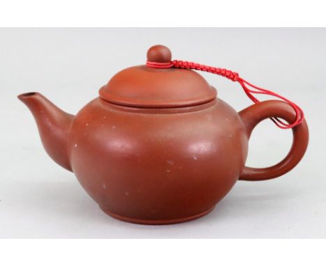 A Chinese Yixing red stoneware teapot and cover, of compressed globular form, stamped seal mark, 9.5cm high.